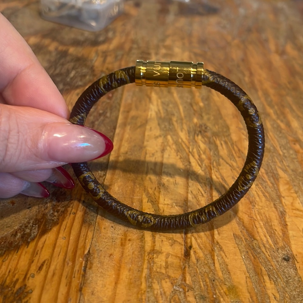Brown leather like and tan bracelet with gold color magnet closure.